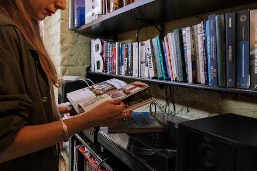 A woman browsing a magazine in a cozy home library with shelves full of books.